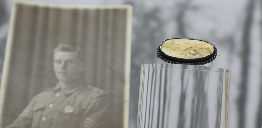 Photo Sergeant Thomas Kitching alonside brooch made from a piece of his thigh bone, displayed in the Stanley and Audrey Burton Gallery