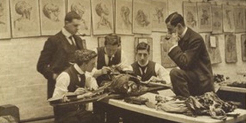 The interior of a dissecting room: five students and/or teachers dissect a cadaver. Photograph, ca. 1900 (?). Wellcome Collection.